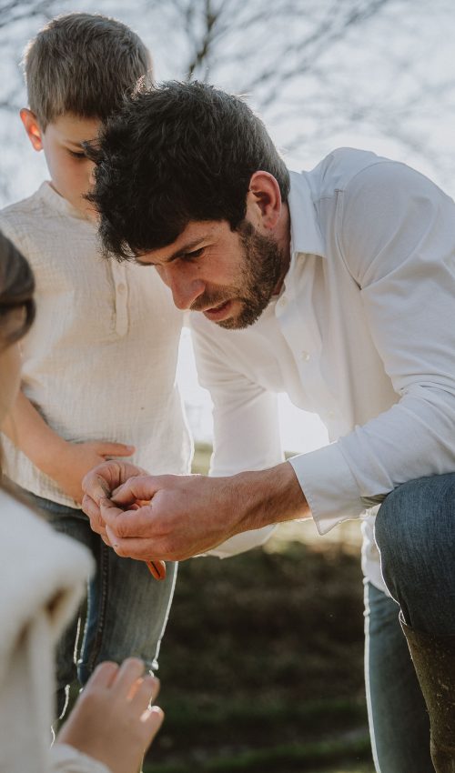 Papa passe un moment de complicité avec ses enfants en plein air à Dax, une séance photo de famille authentique dans les Landes.